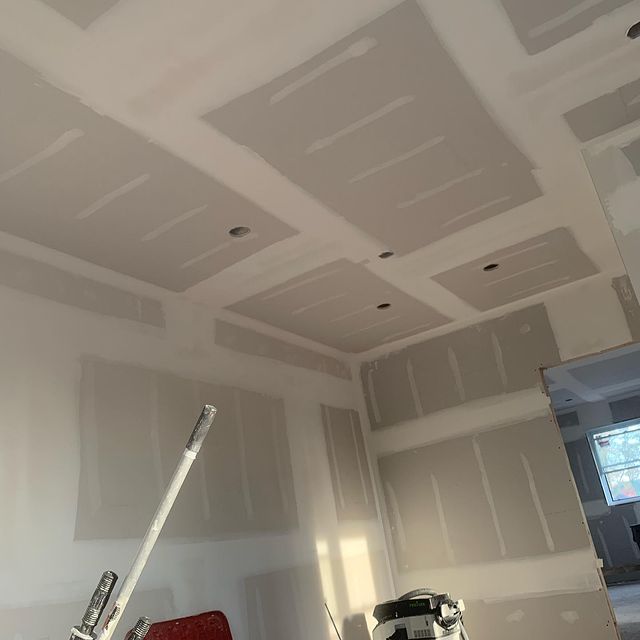A finished drywall wall with a smooth and seamless surface.